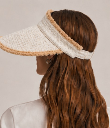 The shaded. visor in cream and natural raffia, worn from behind